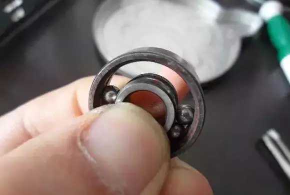 用手將軸承拿起，需要注意要向有滾珠的方向頂住